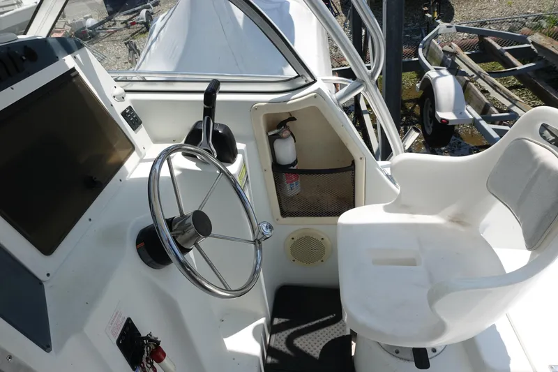 Slide: The Image of 2004 Polar 2300 Walkaround boat cockpit with steering wheel and captain's chair. - 8