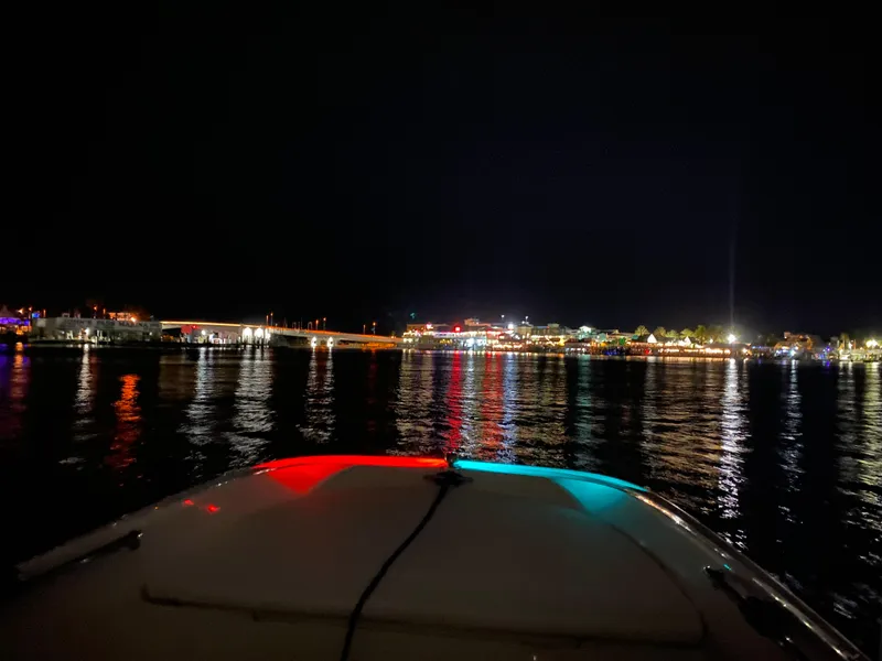 Slide: The Image of 2018 Boston Whaler 150 Super Sport on water at night with city lights reflecting. - 17