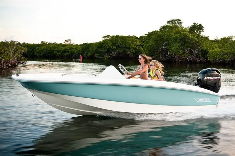 Slide: The Image of 2018 Boston Whaler 150 Super Sport boat cruising on water with two passengers. - 26