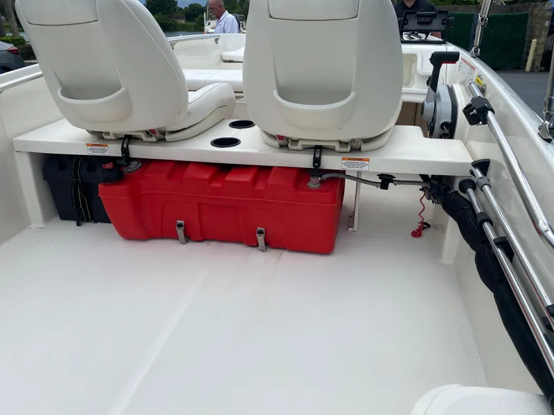 Slide: The Image of 2018 Boston Whaler 150 Super Sport interior with seats and red storage compartment. - 4