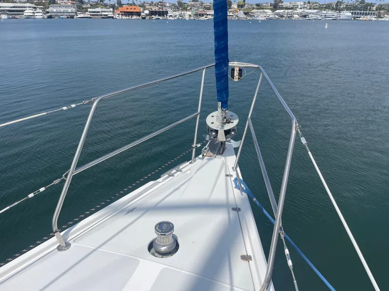 Slide: The Image of Bow of 1999 Catalina 42 MkII sailboat on calm water, marina in background. - 1