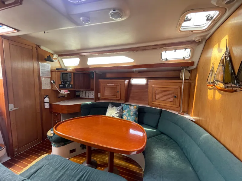 Slide: The Image of Interior of a 1999 Catalina 42 MkII sailboat with cozy seating and wooden table. - 10