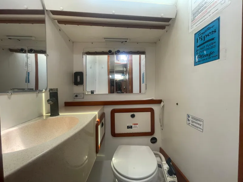 Slide: The Image of Bathroom interior of a 1999 Catalina 42 MkII sailboat, featuring a sink and toilet. - 4
