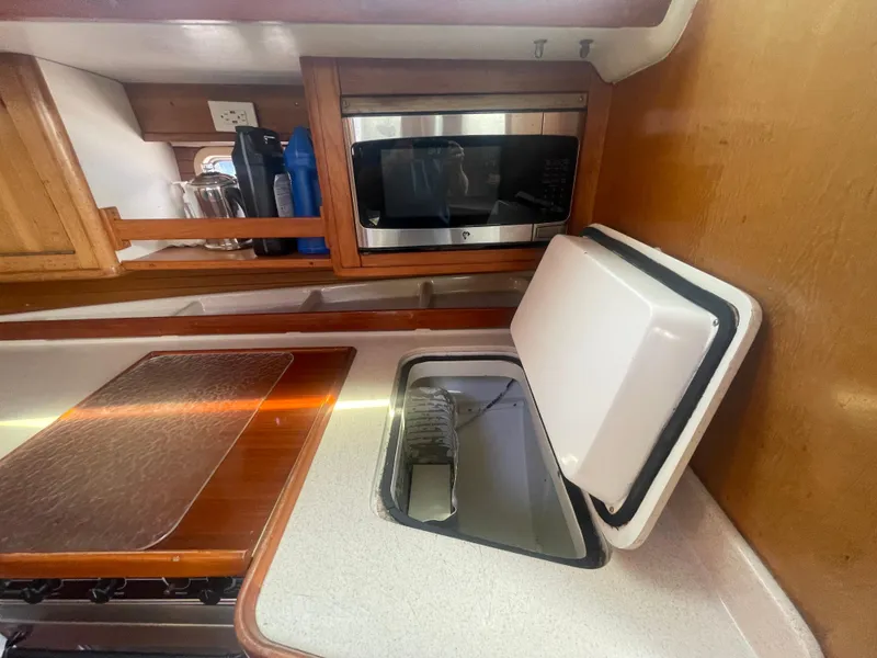 Slide: The Image of Interior of 1999 Catalina 42 MkII yacht kitchen with microwave and open storage compartment. - 5
