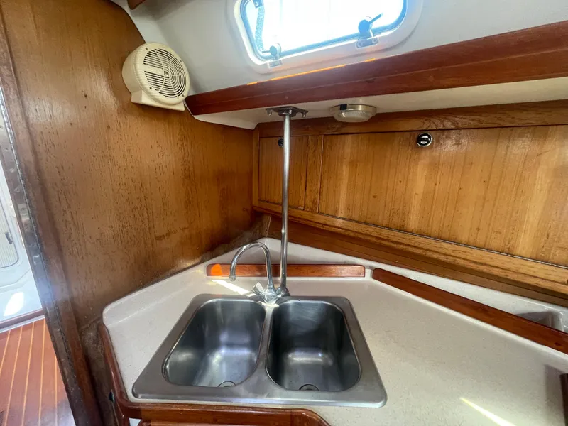 Slide: The Image of Galley sink area in 1999 Catalina 42 MkII sailboat with wooden cabinetry. - 7