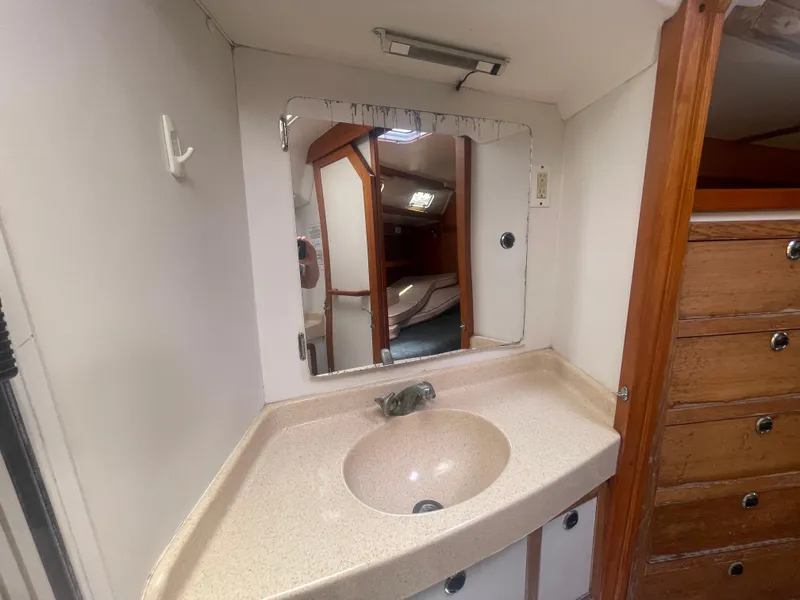 Slide: The Image of 1999 Catalina 42 MkII bathroom with sink, mirror, and wooden cabinetry. - 9