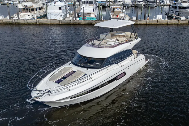 Slide: The Image of 2019 Prestige 460 yacht cruising in a marina, surrounded by other boats. - 14