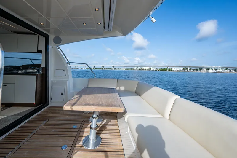 Slide: The Image of Luxurious 2019 Prestige 460 yacht deck with seating, table, and scenic water view. - 22