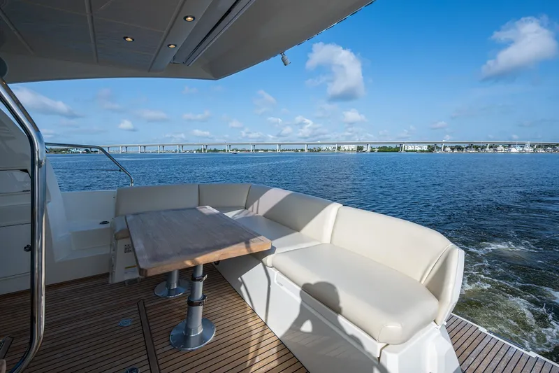 Slide: The Image of Luxury yacht deck with seating and table, Prestige 460, 2019 model, overlooking serene waters. - 24