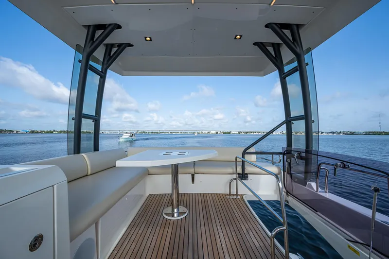 Slide: The Image of Luxurious 2019 Prestige 460 yacht deck with seating, table, and scenic water view. - 38