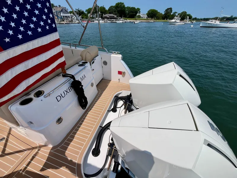 Slide: The Image of 2019 MJM 35z boat with dual engines, American flag, docked in a scenic harbor. - 6