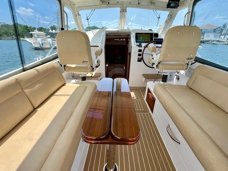 Slide: The Image of Interior of 2019 MJM 35z boat with beige seating and wooden table. - 20