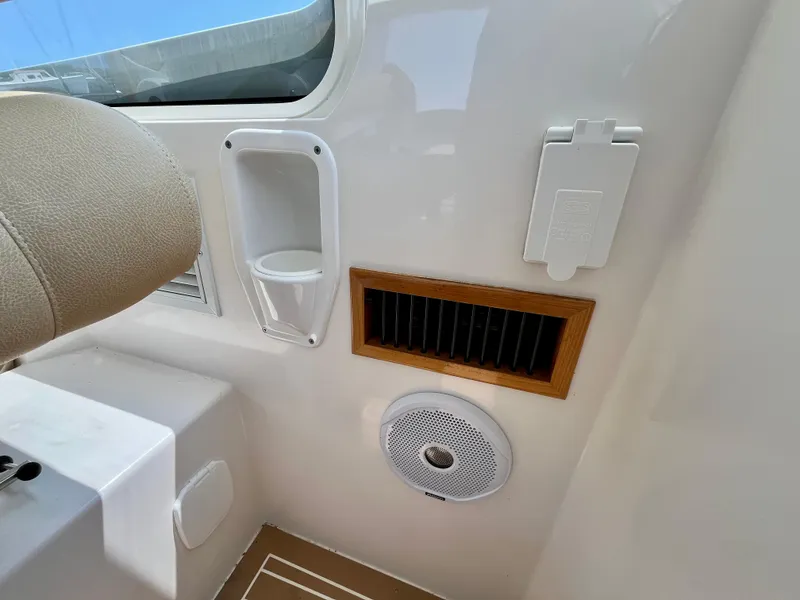 Slide: The Image of Interior of a 2019 MJM 35z boat showing a vent, speaker, and cup holder. - 49