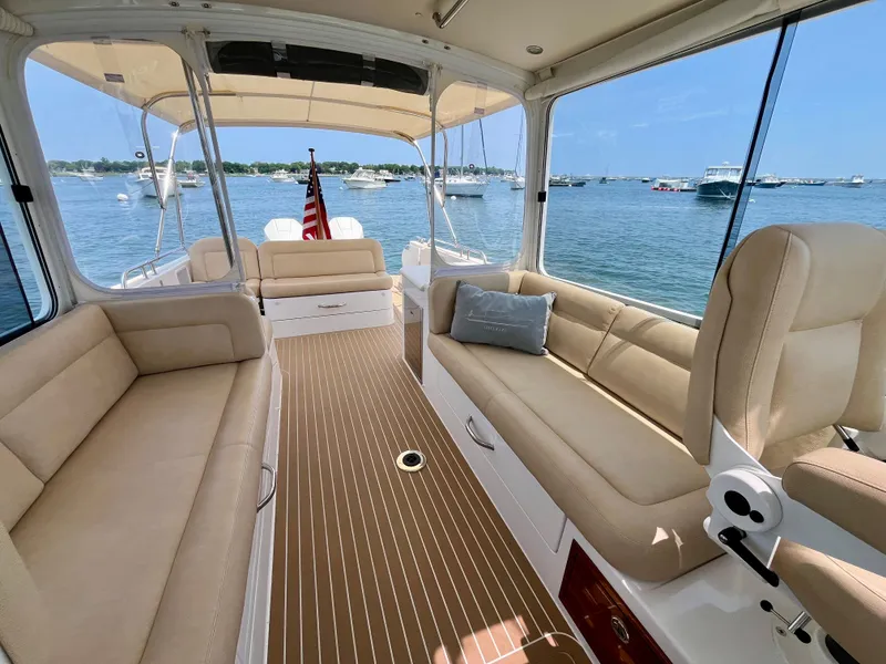 Slide: The Image of 2019 MJM 35z yacht interior with beige seating, wooden flooring, and scenic water view. - 24
