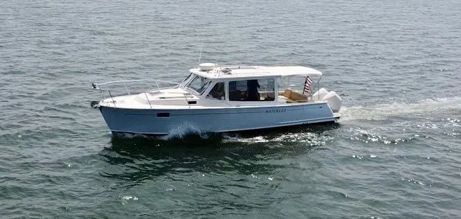 Slide: The Image of 2019 MJM 35z boat cruising on open water. - 2