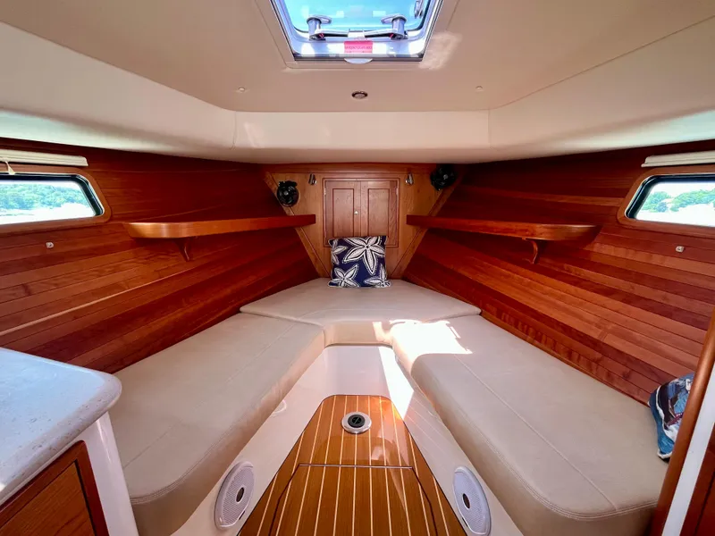 Slide: The Image of Interior of 2019 MJM 35z boat with wooden paneling and beige seating. - 38