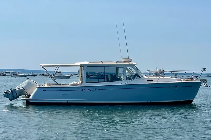 The Image of A 2019 MJM 35z boat on calm water, featuring a sleek white hull and enclosed cockpit. - 0