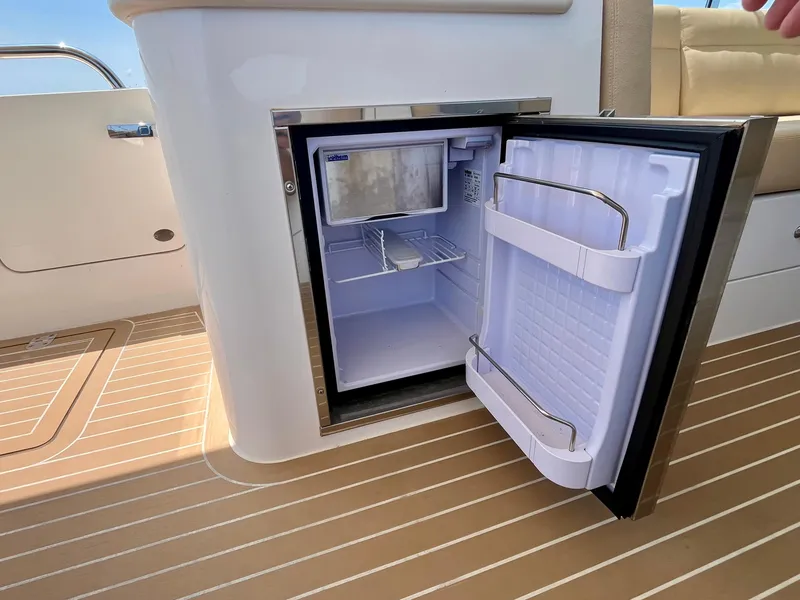 Slide: The Image of Open mini fridge on 2019 MJM 35z boat, showcasing interior storage space. - 17
