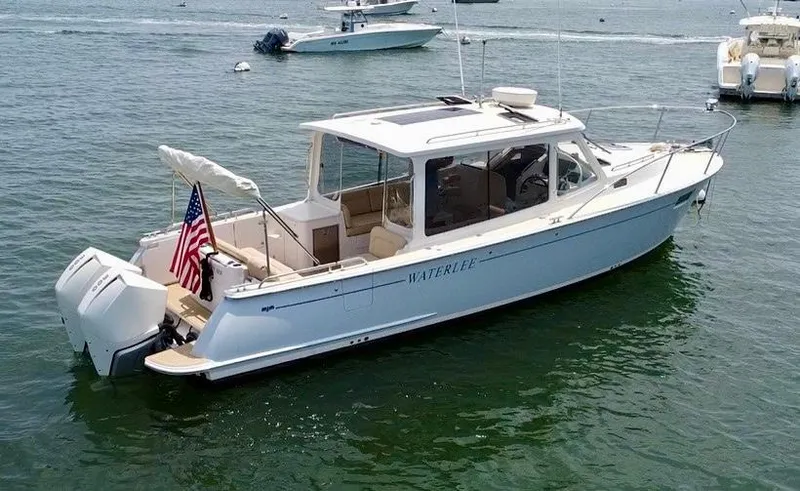 Slide: The Image of 2019 MJM 35z boat on water, featuring sleek design and American flag. - 1