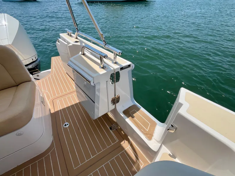 Slide: The Image of 2019 MJM 35z boat deck with tan seating and swim platform on calm water. - 11