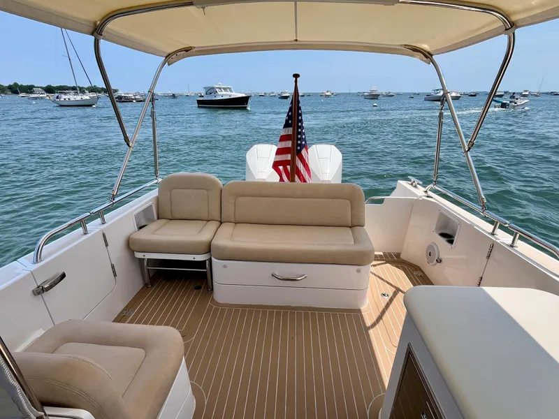 Slide: The Image of 2019 MJM 35z boat interior with beige seating, American flag, and ocean view. - 39