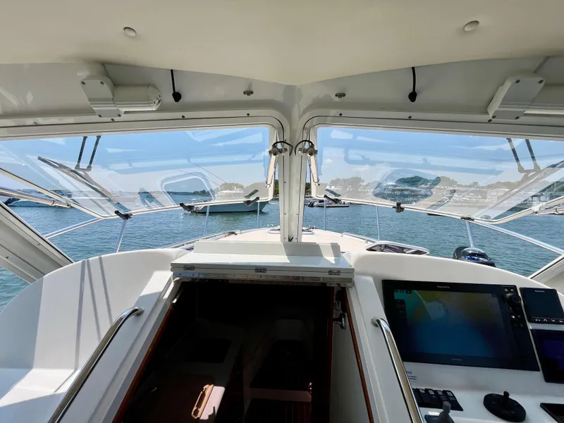 Slide: The Image of 2019 MJM 35z yacht cockpit with open windows, overlooking a serene waterfront view. - 48