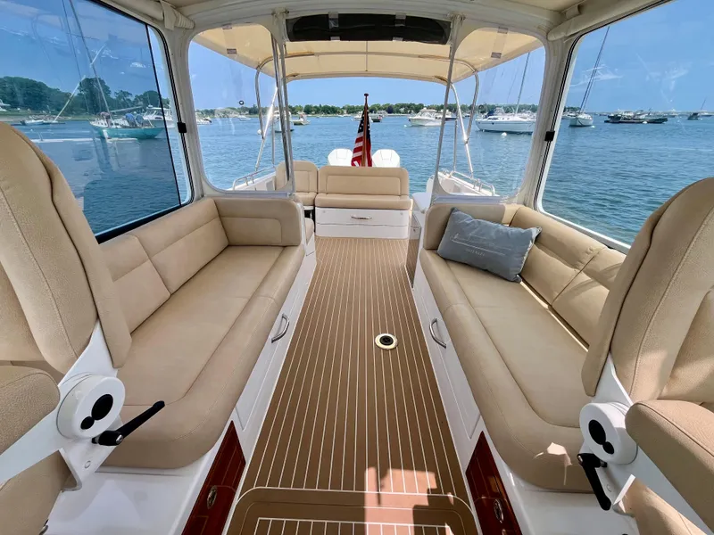 Slide: The Image of 2019 MJM 35z boat interior with beige seating, wooden flooring, and scenic water view. - 45