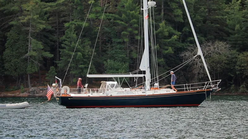 Slide: The Image of 1987 Hinckley Sou'wester 42 sailboat on a calm lake with forested background. - 1