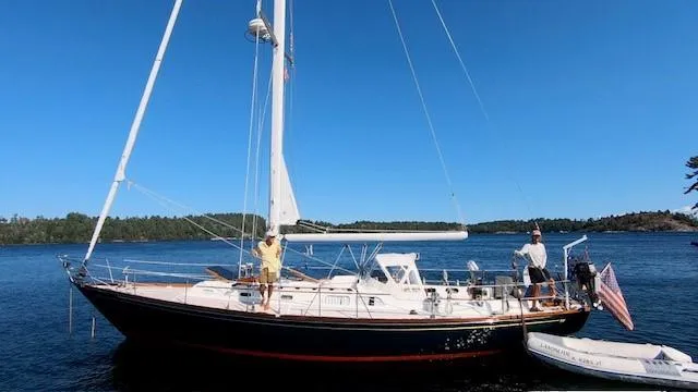 Slide: The Image of 1987 Hinckley Sou'wester 42 sailboat on calm water, clear blue sky background. - 10