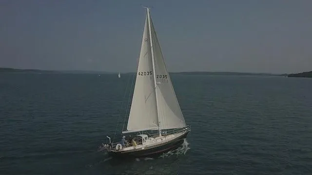 Slide: The Image of 1987 Hinckley Sou'wester 42 sailboat cruising on open water under clear skies. - 13