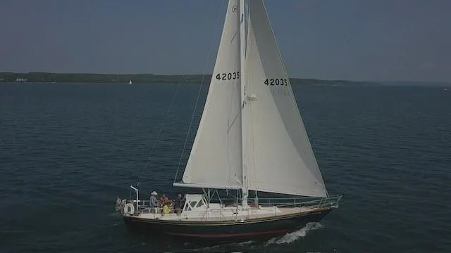 Slide: The Image of 1987 Hinckley Sou'wester 42 sailboat cruising on open water under clear skies. - 14