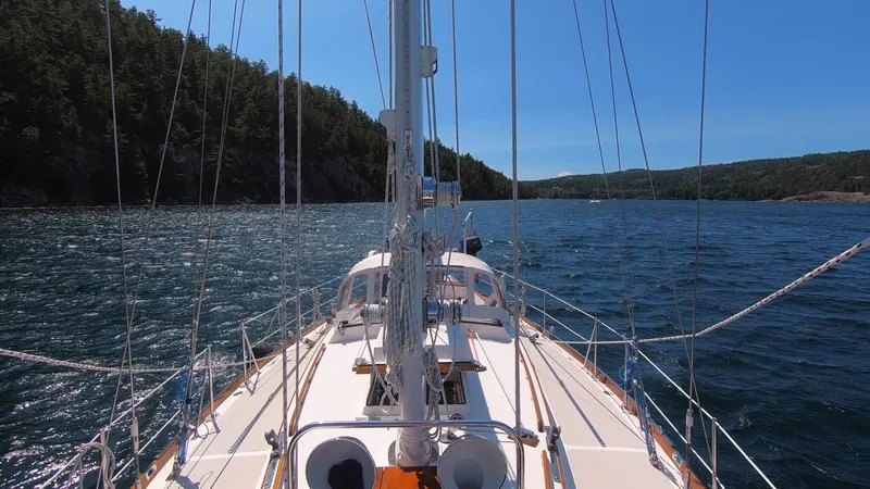 Slide: The Image of Hinckley Sou'wester 42 sailboat from 1987 navigating scenic coastal waters. - 2