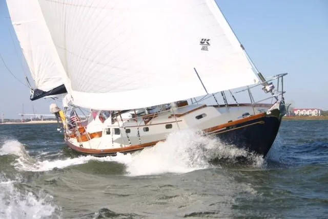 Slide: The Image of 1967 Hinckley Bermuda 40 sailboat navigating through waves with full sails. - 1