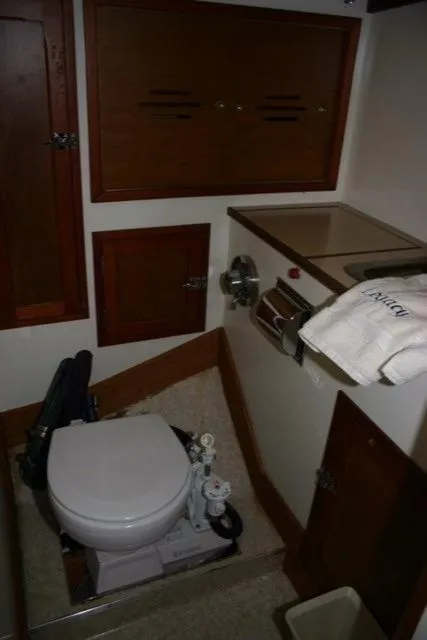 Slide: The Image of 1967 Hinckley Bermuda 40 yacht bathroom with wooden cabinets and compact toilet. - 17