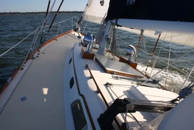 Slide: The Image of 1967 Hinckley Bermuda 40 sailboat navigating on open water, showcasing deck and sails. - 7
