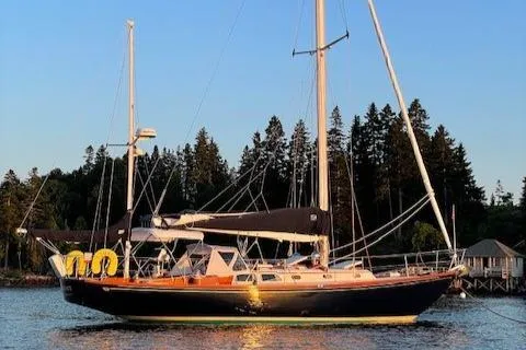 The Image of 1967 Hinckley Bermuda 40 sailboat on calm water, surrounded by trees. - 0