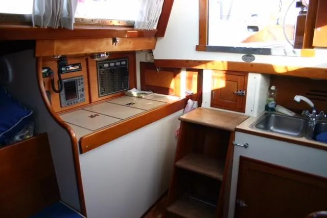 Slide: The Image of Interior of 1967 Hinckley Bermuda 40 sailboat with wooden cabinetry and compact kitchen area. - 11