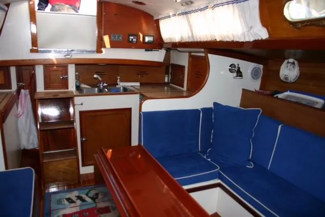 Slide: The Image of Interior of a 1967 Hinckley Bermuda 40 sailboat with blue seating and wooden cabinetry. - 13