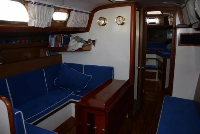 Slide: The Image of Interior of a 1967 Hinckley Bermuda 40 sailboat with blue seating and wooden accents. - 14