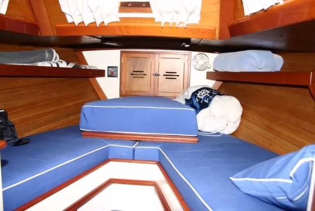 Slide: The Image of Interior cabin of 1967 Hinckley Bermuda 40 sailboat with blue cushions and wooden finish. - 16