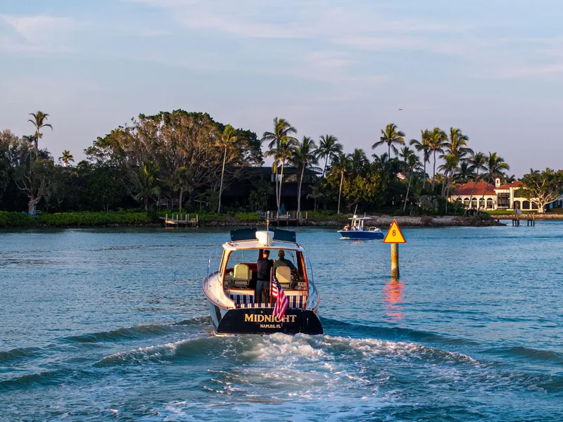 Slide: The Image of Hinckley Picnic Boat 37 MKIII cruising near palm-lined shore, 2014 model. - 15