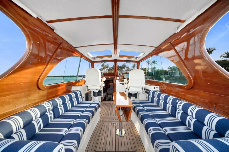 Slide: The Image of Luxurious 2014 Hinckley Picnic Boat 37 MKIII interior with striped seating and wooden finishes. - 4