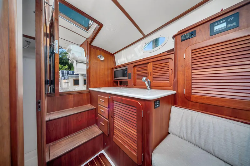 Slide: The Image of 2014 Hinckley Picnic Boat 37 MKIII interior with wooden cabinetry and seating. - 7