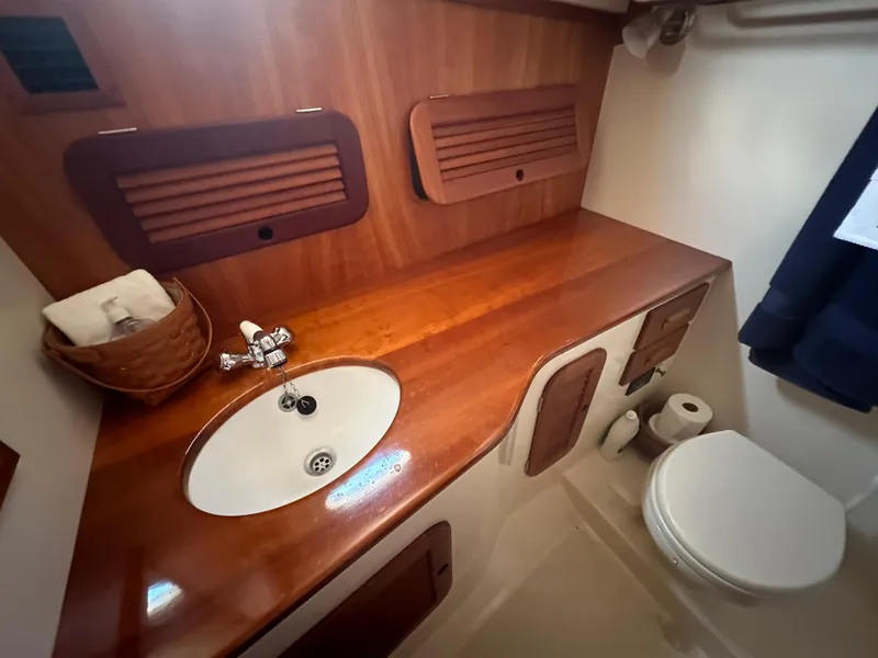 Slide: The Image of Hinckley Picnic Boat 37 MKIII 2009 bathroom with wooden countertop, sink, and toilet. - 10