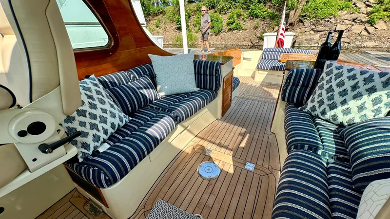 Slide: The Image of Luxurious 2009 Hinckley Picnic Boat 37 MKIII with elegant striped seating and wooden deck. - 2