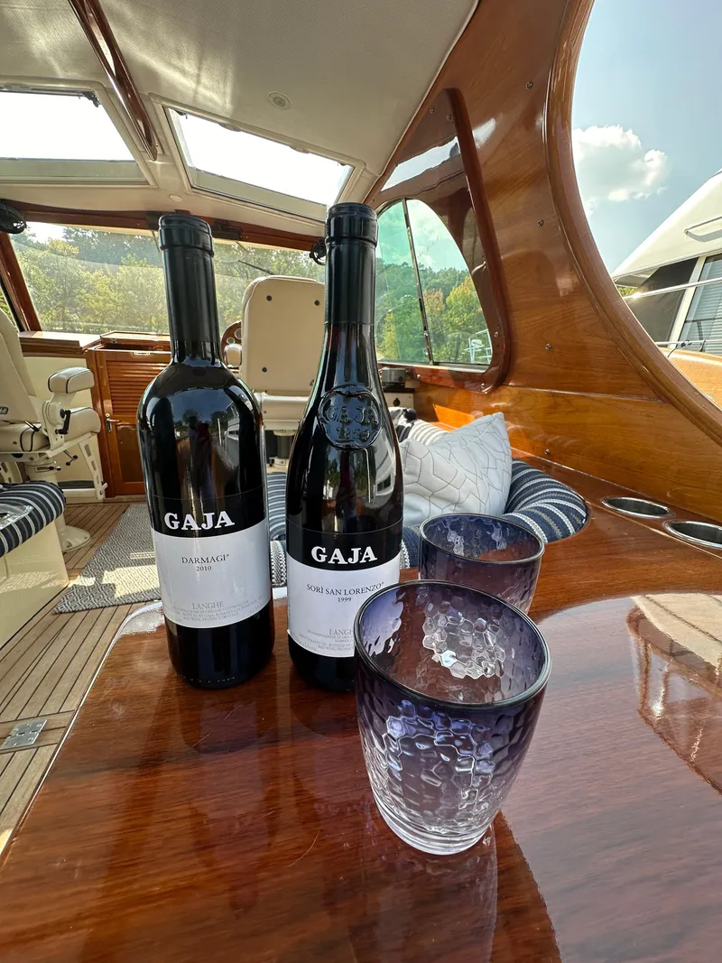 Slide: The Image of Hinckley Picnic Boat 37 MKIII interior with wine bottles and glasses on a wooden table. - 3
