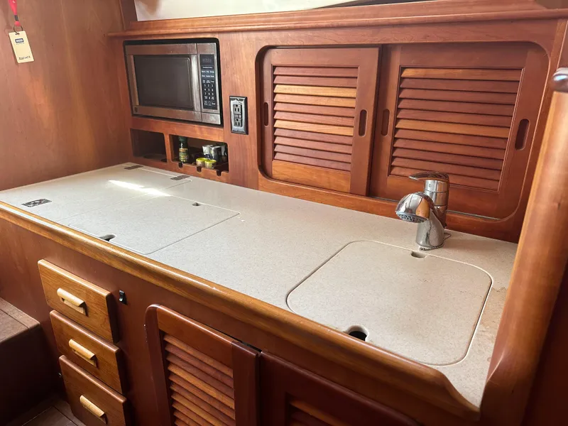 Slide: The Image of Hinckley Picnic Boat 37 MKIII 2009 galley with wooden cabinets, sink, and microwave. - 5