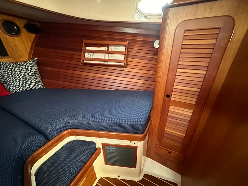 Slide: The Image of Cozy cabin interior of 2009 Hinckley Picnic Boat 37 MKIII with wooden paneling and blue bedding. - 8