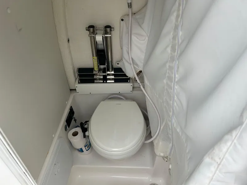 Slide: The Image of 2020 Tidewater 272 CC Adventure boat bathroom with toilet and shower curtain. - 11