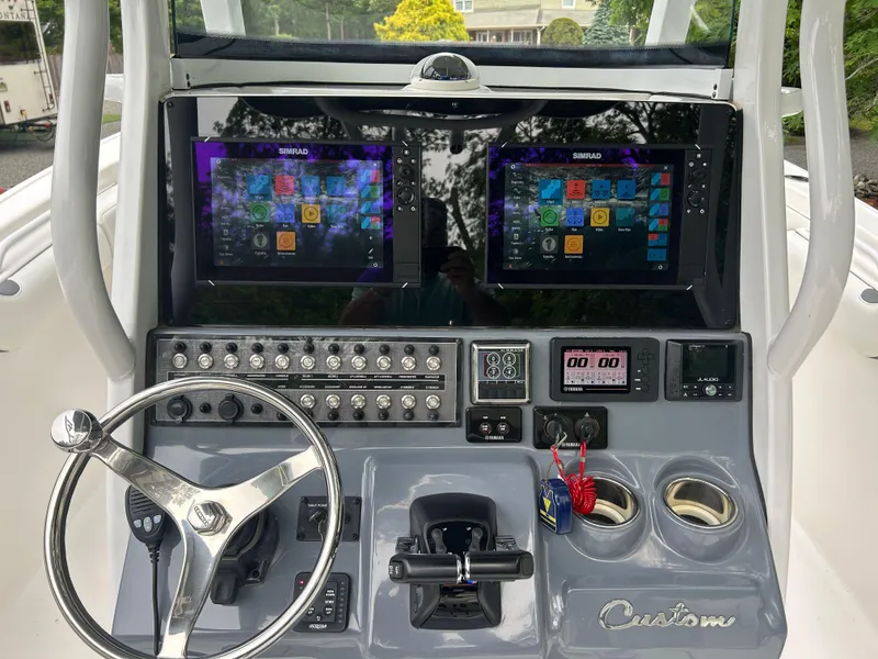 Slide: The Image of 2020 Tidewater 272 CC Adventure boat dashboard with dual Simrad displays and steering wheel. - 13